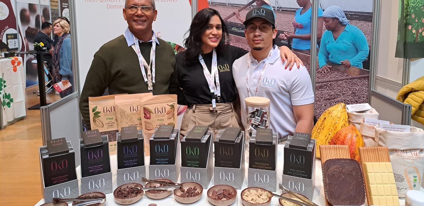 Three people stand behind chocolate samples from Dominican Republic