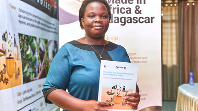 Ghanaian woman holds coffee processing handbook