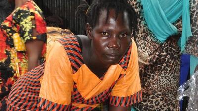 South Sudanese woman stands over vegetable stand in market