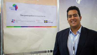 Young Egyptian businessman stands by ITC display at trade show