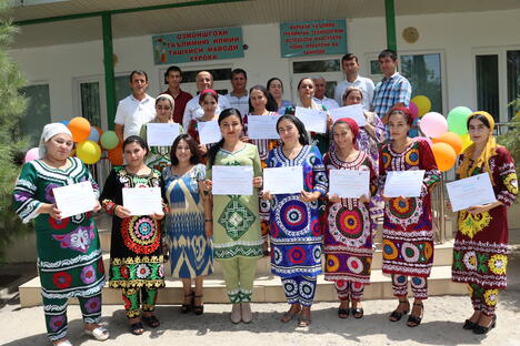 Group of people outside holding certificates from the Garment Training Centres in Tajikistan