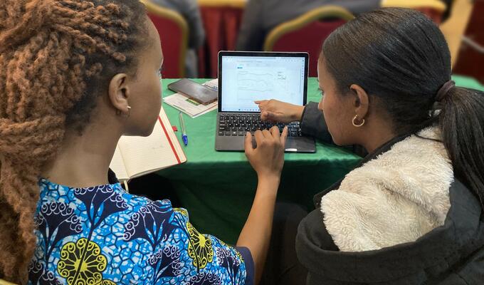 Two African trade officials look at computer screen with ATO digital tools