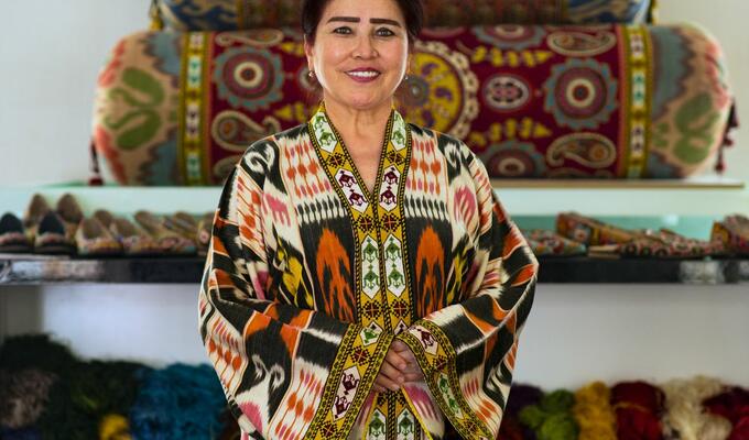 Woman poses in jacket designed in traditional patterns of Central Asia