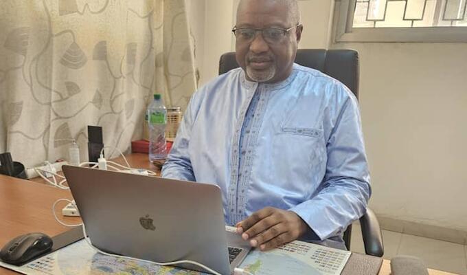 Senegalese man in blue shirt sits at laptop