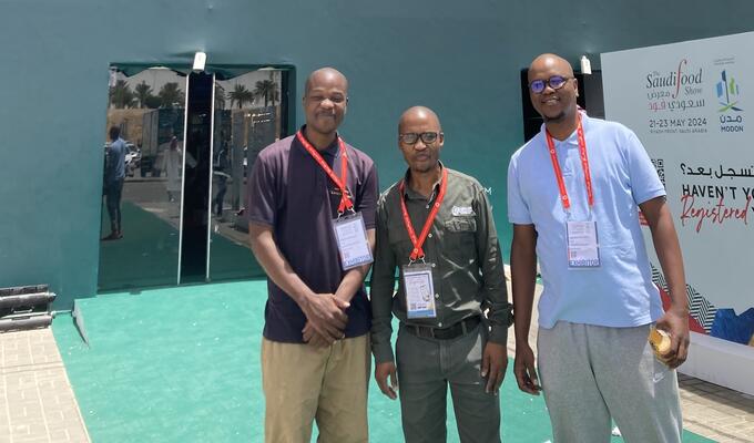 Three African entrepreneurs stand outside the conference centre hosting the Saudi Food Show