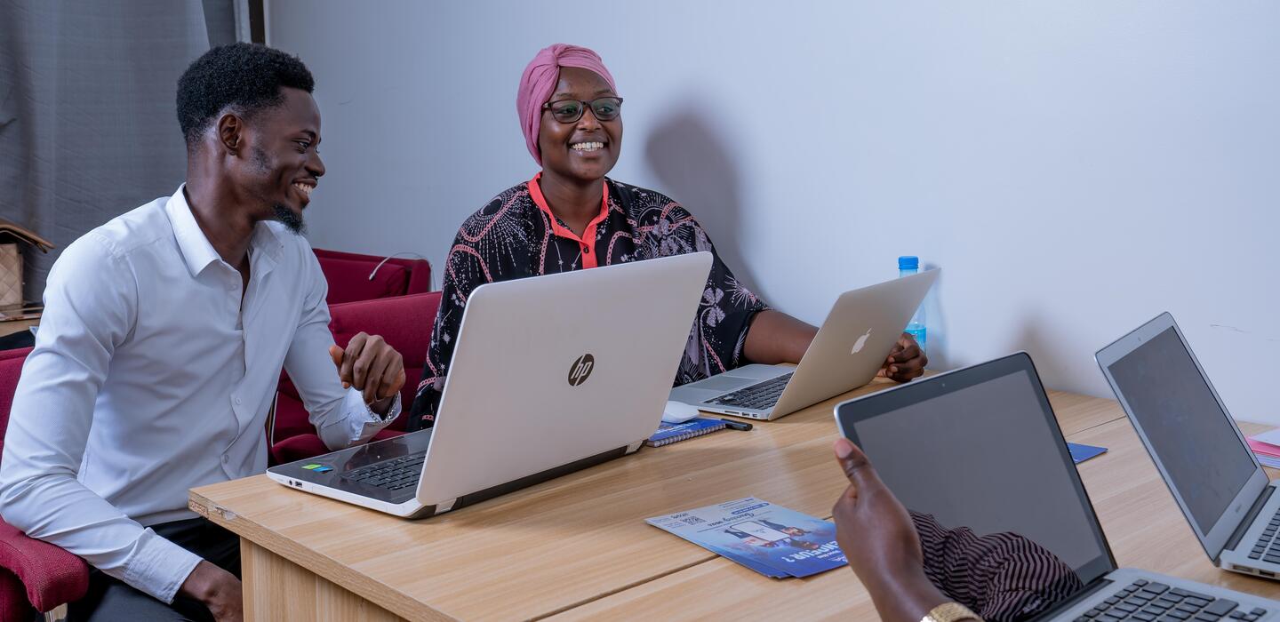 Deux Africains souriants devant leur ordinateur portable