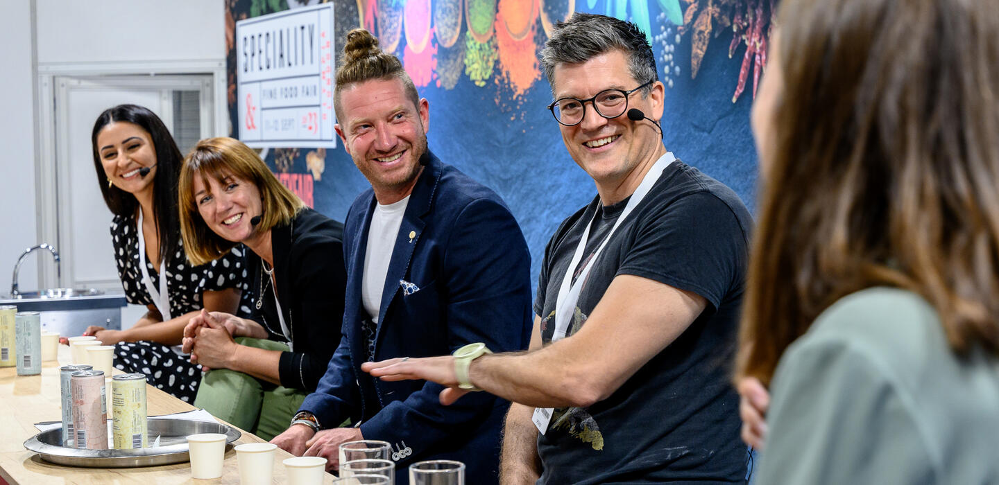 Four judges speak on a panel at a food show