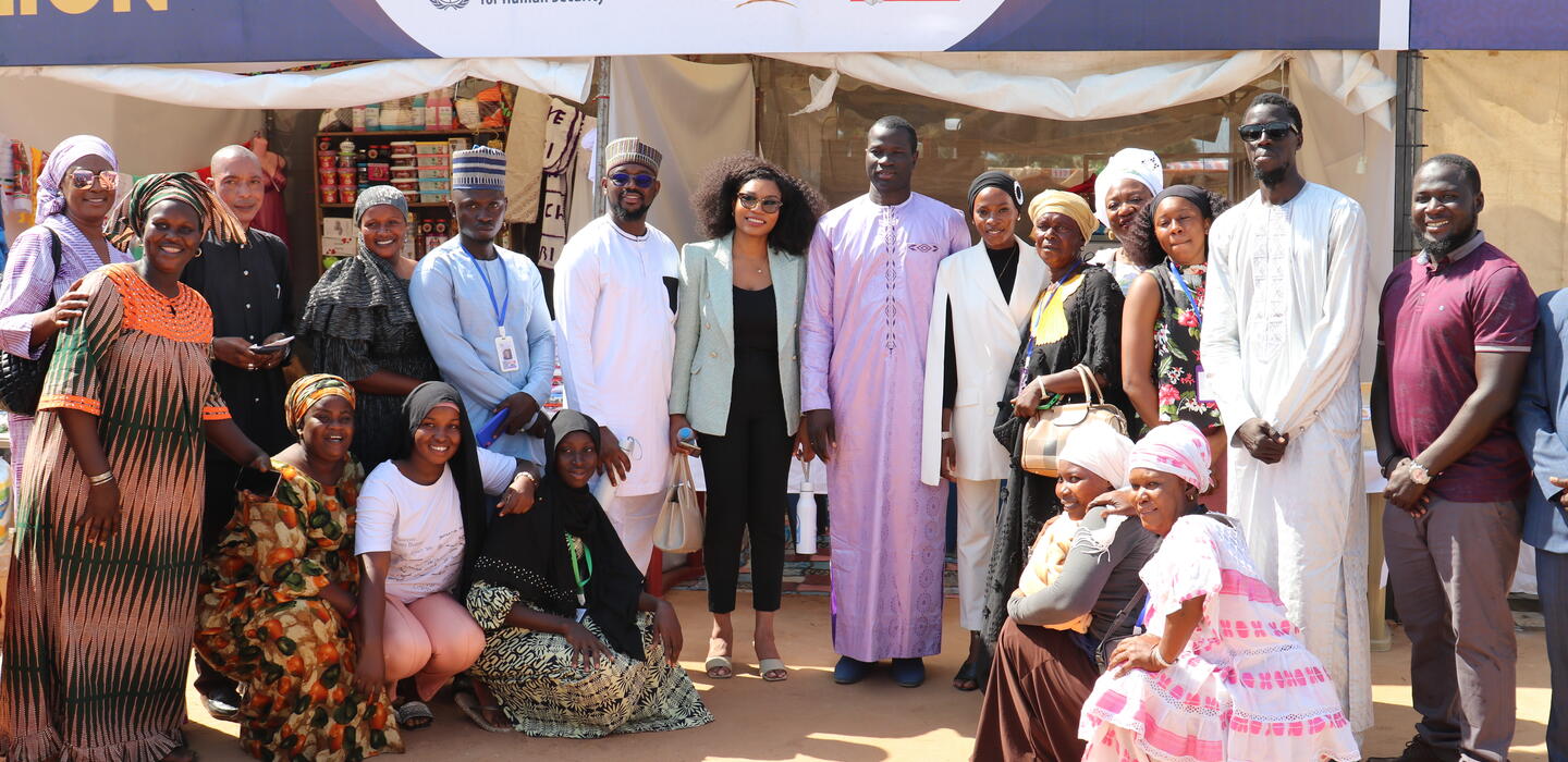 Group of Gambian women who work as cross-border traders pose with a government minister at a trade fair