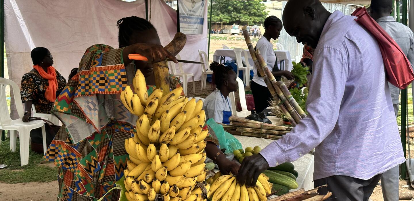 A farmer displays bananas from her field at the trade fair.