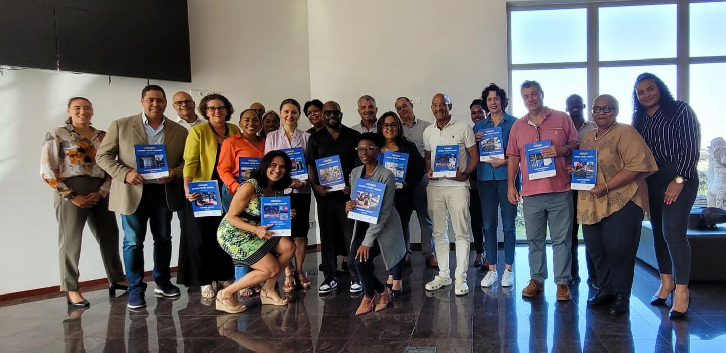 Group of business leaders in Curaçao holding copies of the national export strategy