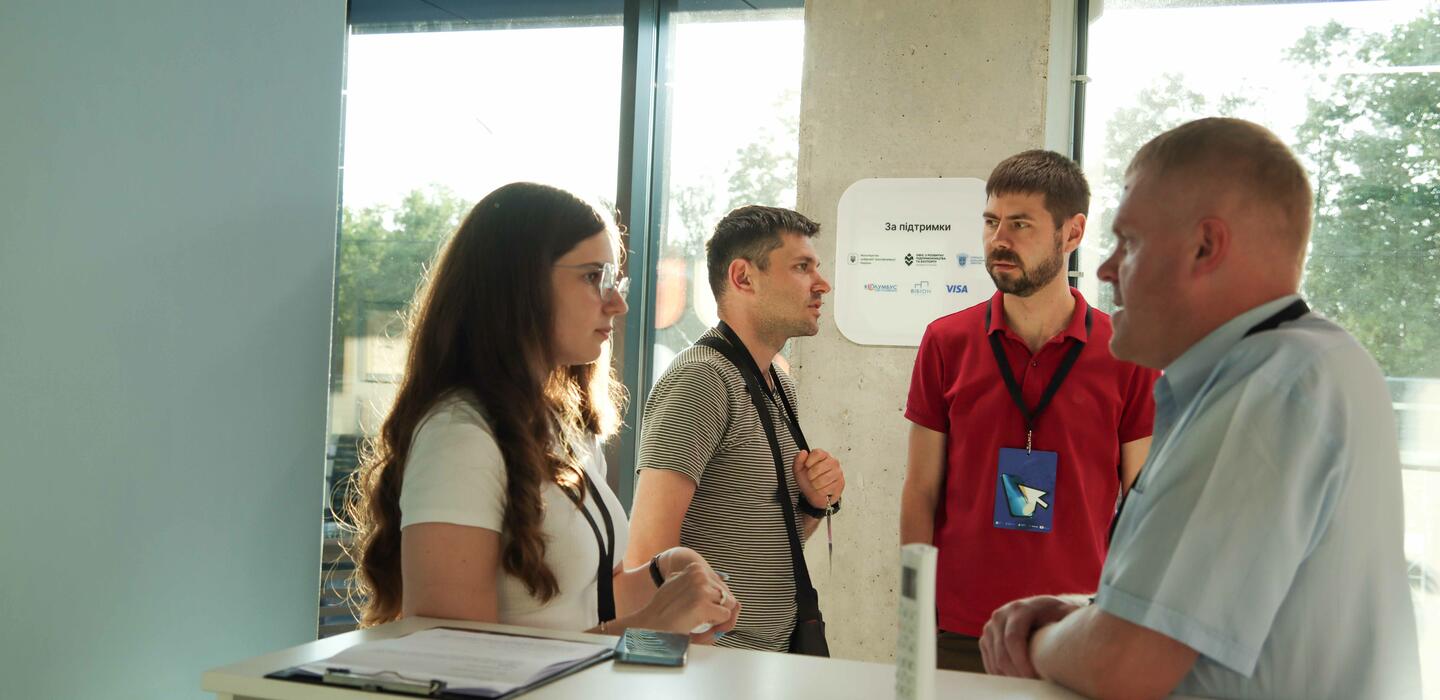 Four Ukrainian entrepreneurs talk near counter