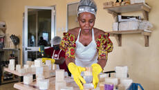 Woman in Guinea arranges stacks of newly made soap
