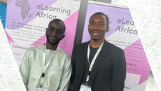 Two men stand in front of eLearning Africa banner