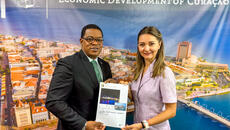 Curaçao Minister of Economic Development Ruisandro Cijntje holds copy of book labelled national export strategy