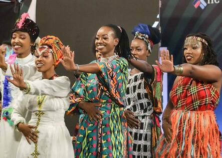 Kenyan group sings and dances in contemporary African dress on stage for reality show